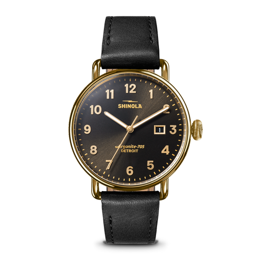 Shinola Airside-205 Detroit watch with a gold-tone case, black dial, and black leather strap, shown against a plain white background.