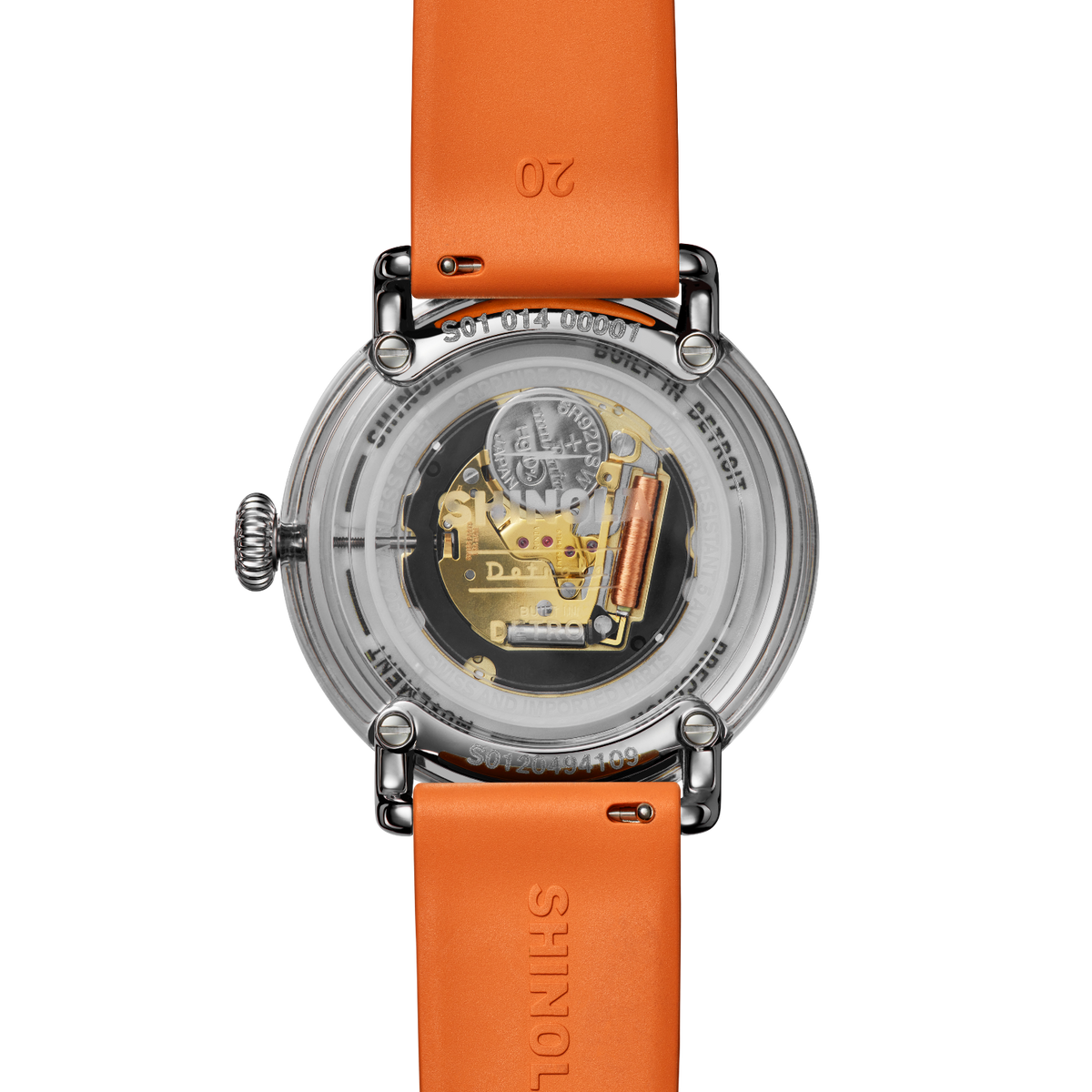 Shinola wristwatch with an orange leather strap and a clear round case showing the gold-toned mechanical movement inside, photographed on a white background.